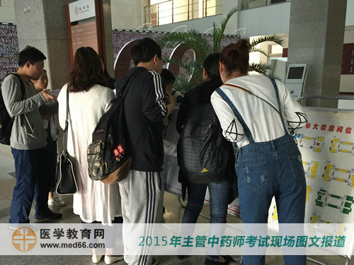 在考点指引牌前查看主管中药师考场位置的考生 
